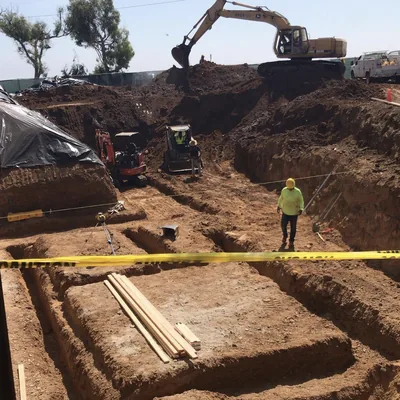 Excavation under way for a building foundation, with a crew member on site