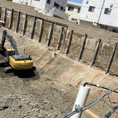 An excavator beside a timber-lagged shoring wall