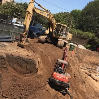 An excavator and a mini excavator digging out a site